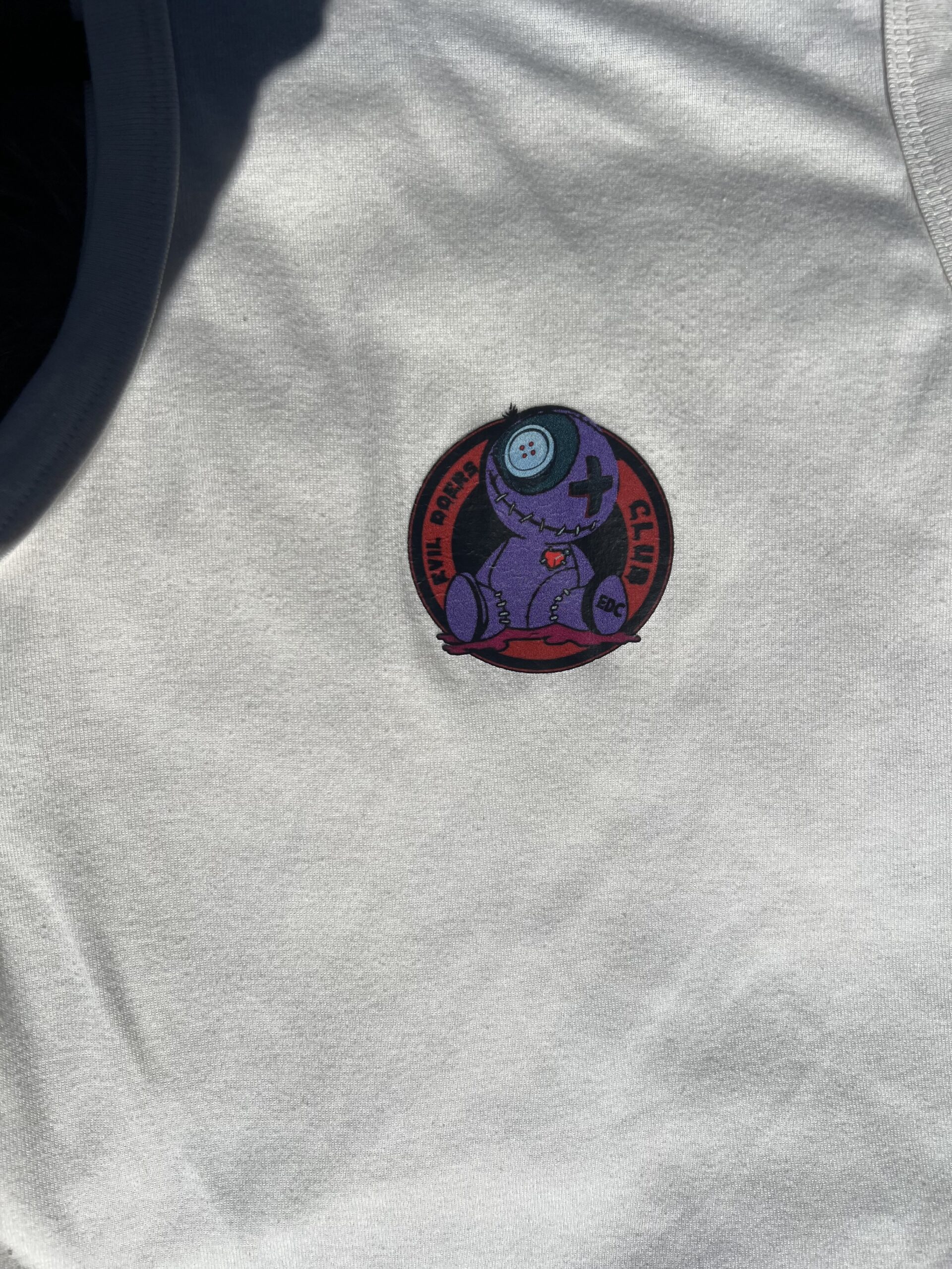 Off White Racerback Tank With Circular Voodoo Doll Logo